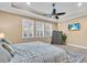 Serene bedroom featuring a tray ceiling, a ceiling fan, three windows, neutral tones, with a large bed and a TV at 5001 65Th E Ter, Ellenton, FL 34222