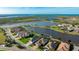 Wide aerial view highlighting homes with pools, and a backdrop of picturesque lakes and distant ocean at 508 Wildlife Gln, Bradenton, FL 34209