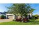 Charming home exterior featuring a well-manicured lawn, mature tree, and three-car garage at 508 Wildlife Gln, Bradenton, FL 34209