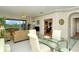 Open concept dining area with glass table and view into living room at 5150 Mahogany Run Ave, Sarasota, FL 34241