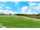 Green grass and a pond create a peaceful golf course view at 5150 Mahogany Run Ave, Sarasota, FL 34241