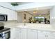 Kitchen with white cabinets, stainless steel appliances, and view of living room at 5150 Mahogany Run Ave, Sarasota, FL 34241