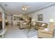 Bright living room with two sofas, a coffee table, and a view into the kitchen at 5150 Mahogany Run Ave, Sarasota, FL 34241