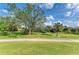 Backyard view with mature trees and green lawn at 5304 96Th E St, Bradenton, FL 34211