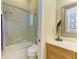 Bathroom with a glass-enclosed shower over a tub, decorative shower tiles, and a vanity with a marble countertop at 5304 96Th E St, Bradenton, FL 34211