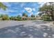 Clubhouse and parking lot, with mature trees, a paved lot, and a partly cloudy sky at 5304 96Th E St, Bradenton, FL 34211