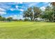 Expansive golf course view showcasing the green, mature trees, and a partly cloudy sky at 5304 96Th E St, Bradenton, FL 34211