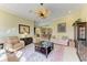 A cozy living room with neutral colors, a ceiling fan, and view into the kitchen and bar at 5304 96Th E St, Bradenton, FL 34211