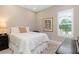 Charming bedroom with a full-size bed, window seat, and neutral decor at 5361 Salcano St, Sarasota, FL 34238