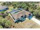 Aerial view of a beautiful home with a screened-in pool and fenced yard, surrounded by lush greenery at 5551 Allamanda Ave, North Port, FL 34288