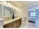 Bathroom featuring double vanity sinks, granite counters and views into the bedroom at 5551 Allamanda Ave, North Port, FL 34288