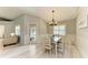 Bright dining room features modern light fixture, wainscoting, wood floors and a sliding glass door to the pool at 5551 Allamanda Ave, North Port, FL 34288