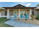 Charming front porch featuring decorative chairs, a wreath on the light blue door, and a welcoming entrance area at 5551 Allamanda Ave, North Port, FL 34288