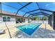 Inviting pool with screened-in enclosure offering a comfortable seating area and scenic backyard views at 5551 Allamanda Ave, North Port, FL 34288