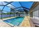 Sparkling screened-in pool offers a refreshing retreat with ample lounge space and modern brick pavers at 5551 Allamanda Ave, North Port, FL 34288