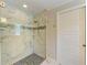 Glass enclosed shower features mosaic tile and river rock flooring at 5551 Allamanda Ave, North Port, FL 34288