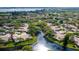 Aerial view of a residential area with mature trees and a winding waterway in the landscape at 5653 Pipers Waite # 26, Sarasota, FL 34235