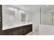 Modern bathroom featuring double sinks, dark wood cabinetry, and a frameless glass shower enclosure at 5653 Pipers Waite # 26, Sarasota, FL 34235