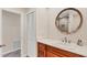 Bathroom featuring a sink, wooden vanity, and a mirror. It has a view to a shower behind a door at 5653 Pipers Waite # 26, Sarasota, FL 34235