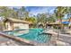 Community pool with a brick surround, blue umbrellas, and lounge chairs at 5653 Pipers Waite # 26, Sarasota, FL 34235