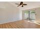 Bright bedroom with ceiling fan, sliding glass door, and wood-look floors at 6947 Woodwind Dr # 77, Sarasota, FL 34231