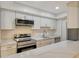 Updated kitchen featuring white cabinets and quartz countertops at 6947 Woodwind Dr # 77, Sarasota, FL 34231