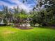 Landscaped backyard with lake view and palm trees at 7724 Us Open Loop, Lakewood Ranch, FL 34202