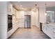 Modern kitchen with white cabinets, stainless steel appliances, and light wood flooring at 7724 Us Open Loop, Lakewood Ranch, FL 34202