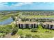 Aerial view showing the building, golf course, lakes, and houses at 8403 Grand Estuary Trl # 301, Bradenton, FL 34212