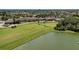 Aerial showcasing golf course, a tranquil lake, and a stunning clubhouse in a lush, green setting at 8403 Grand Estuary Trl # 301, Bradenton, FL 34212