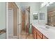 Bathroom featuring wood cabinets, a white countertop, and a walk-in shower with a glass door at 8403 Grand Estuary Trl # 301, Bradenton, FL 34212