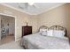 Cozy bedroom featuring neutral-toned walls, carpeted floor, and decorative paisley bedding and a dark wood dresser at 8403 Grand Estuary Trl # 301, Bradenton, FL 34212