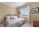 Comfortable bedroom with a window view, neutral walls, paisley bedding and carpeted floor at 8403 Grand Estuary Trl # 301, Bradenton, FL 34212