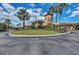 Community entrance with lush landscaping, a circular driveway, and distinct architectural details at 8403 Grand Estuary Trl # 301, Bradenton, FL 34212