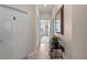 Neutral hallway with tile floors, white doors, and a decorative table with mirror leading to a bedroom at 8403 Grand Estuary Trl # 301, Bradenton, FL 34212