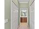 Hallway with a view into the bathroom, featuring neutral paint and a set of closed doors at 8403 Grand Estuary Trl # 301, Bradenton, FL 34212