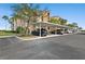 Exterior view showing a covered parking area with several parked cars, surrounded by palm trees and landscaping at 8403 Grand Estuary Trl # 301, Bradenton, FL 34212