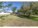 Expansive backyard with multiple trees and lawn at 1006 Pine Forest Ct, Venice, FL 34293