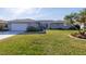 Gray house with white garage door and well-maintained lawn at 1006 Pine Forest Ct, Venice, FL 34293