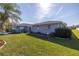 Side view of a single-story house with lush lawn at 1006 Pine Forest Ct, Venice, FL 34293