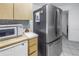 Stainless steel refrigerator and microwave in a galley kitchen at 1006 Pine Forest Ct, Venice, FL 34293