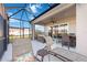 Covered patio with wicker furniture and view of the pool and screened enclosure at 12822 Rainwashed Loop, Parrish, FL 34219