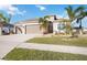 Tan single-story house with a three car garage and lush landscaping at 12822 Rainwashed Loop, Parrish, FL 34219