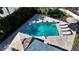 Breathtaking aerial view of a luxury pool featuring integrated spa, stylish loungers, and lush landscaping at 1302 Roberts Bay Ln, Sarasota, FL 34242