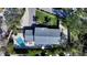 An aerial view showcases the home's layout, pool, landscaping, and proximity to surrounding trees at 1302 Roberts Bay Ln, Sarasota, FL 34242