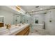 Elegant bathroom featuring double sinks, gold fixtures, soaking tub, and glass enclosed shower at 1302 Roberts Bay Ln, Sarasota, FL 34242