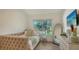 Cozy bedroom featuring a tufted daybed, light wood floors, and a large window at 1302 Roberts Bay Ln, Sarasota, FL 34242