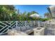 Charming outdoor deck boasts comfortable seating, an umbrella-covered dining table, and a cozy fire pit at 1302 Roberts Bay Ln, Sarasota, FL 34242