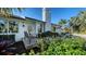 Charming entrance showcasing lush landscaping and a cozy bench, inviting guests to relax at 1302 Roberts Bay Ln, Sarasota, FL 34242