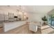 Bright kitchen and dining area with granite countertops, stainless appliances, and modern chandelier lighting at 1302 Roberts Bay Ln, Sarasota, FL 34242